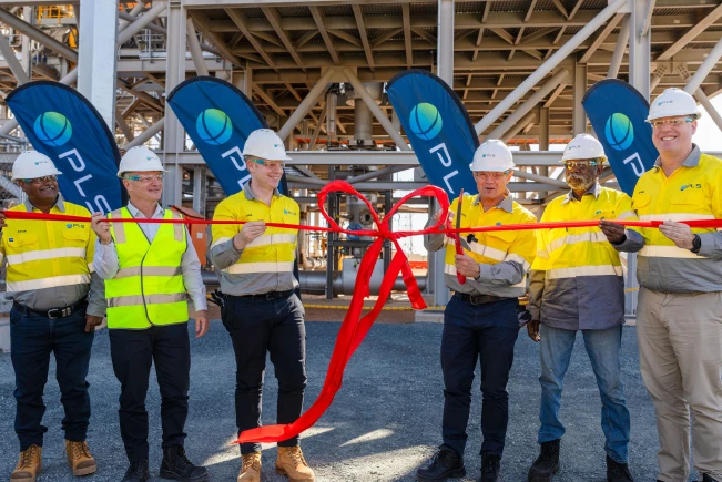 Six people stand behind a red ribbon and Premier Roger Cook has large scissors to cut the ribbon.